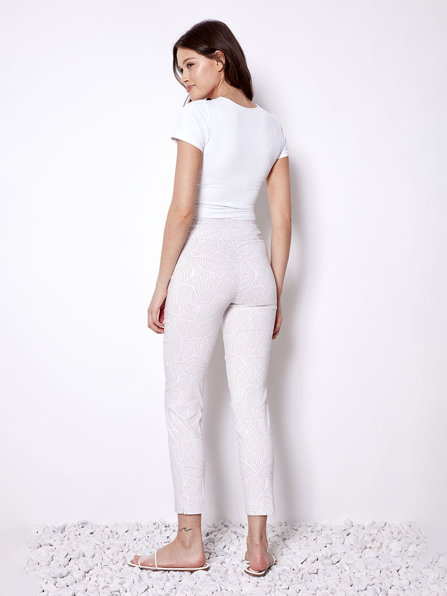 Woman wearing a white outfit standing against a light gray background