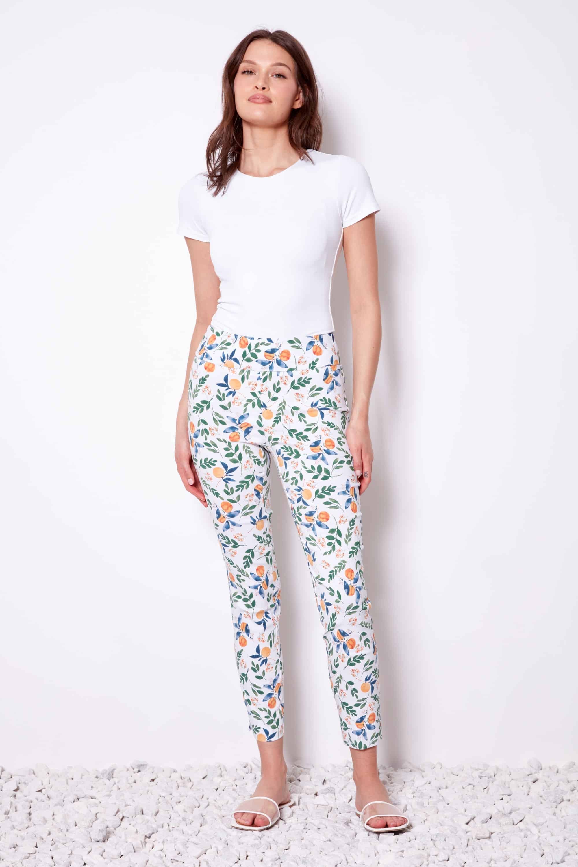 Woman wearing a white t-shirt and floral pants on a white background