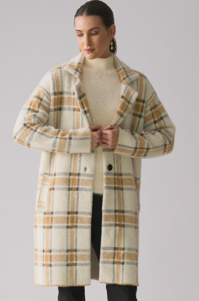 Woman wearing a plaid coat on a plain background