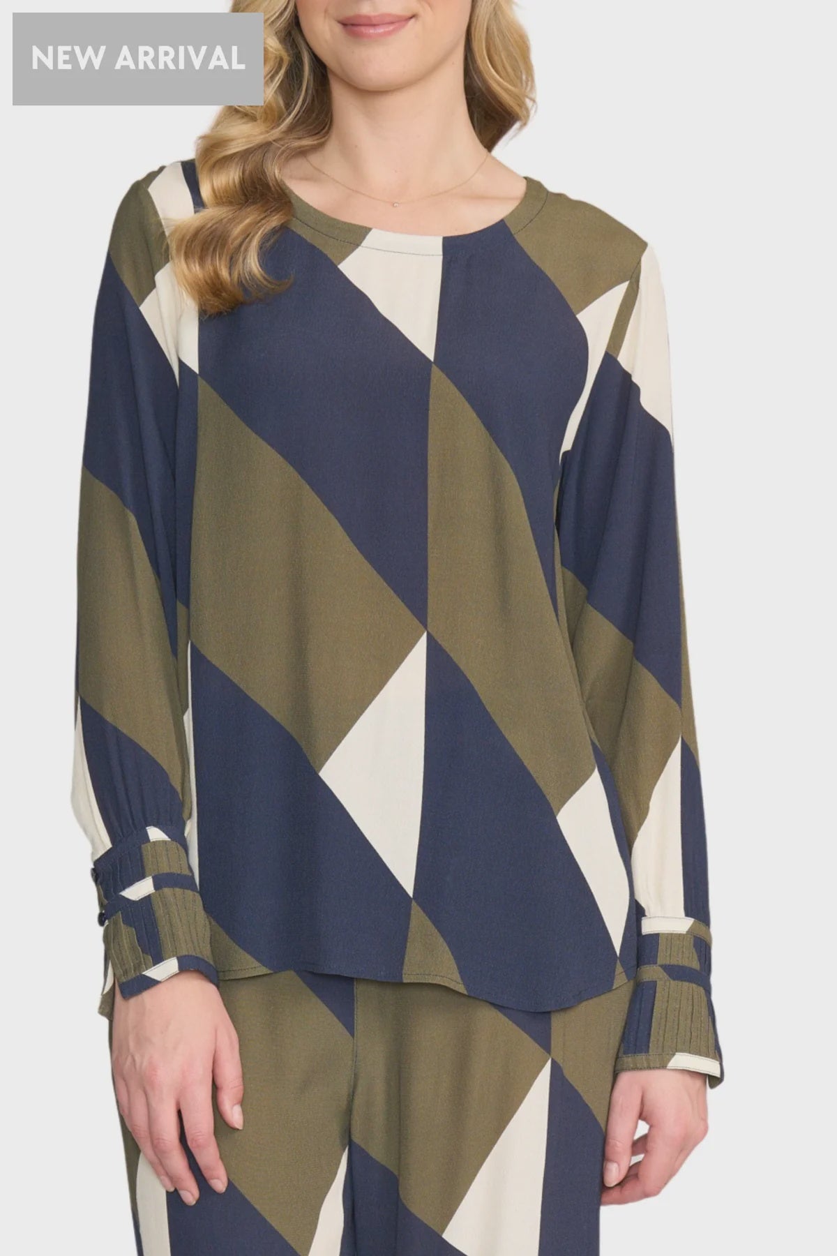 Woman wearing a blue, green, and white patterned top on a white background