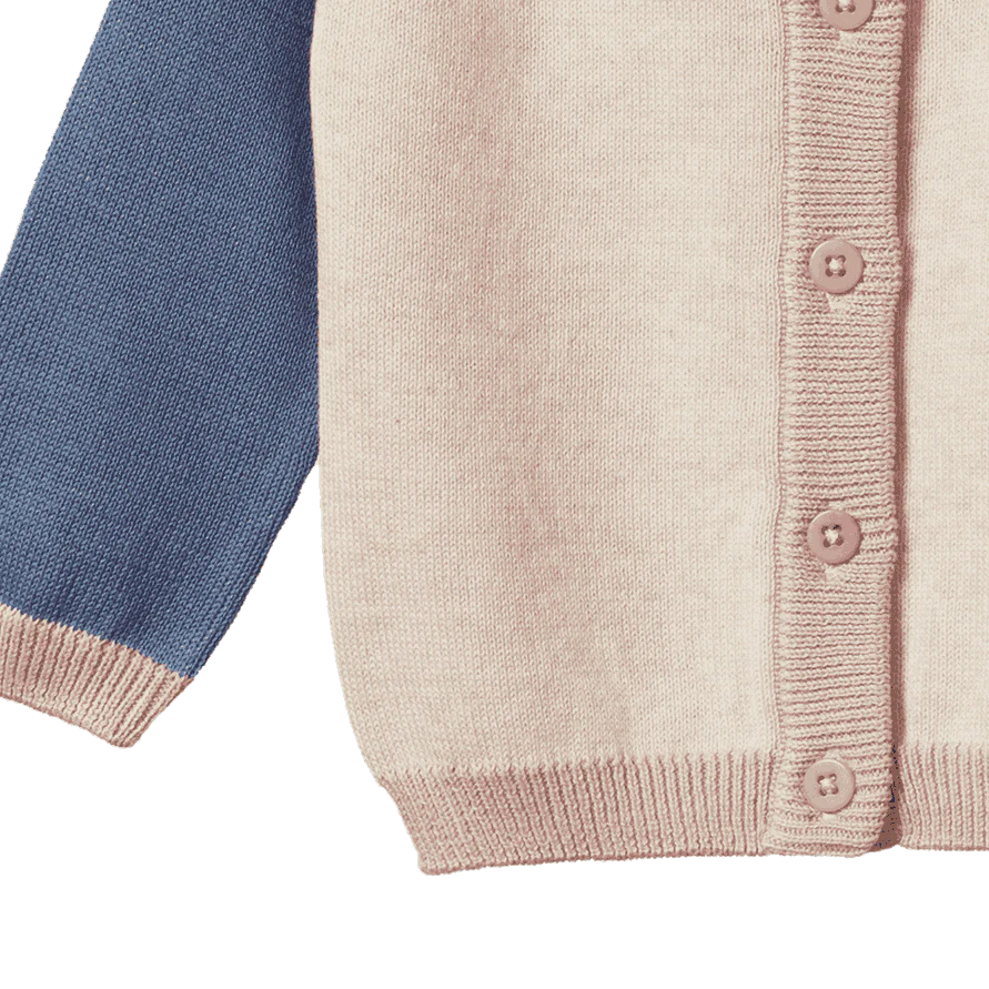 Close-up of a knitted cardigan with blue sleeve and pink buttons on a white background