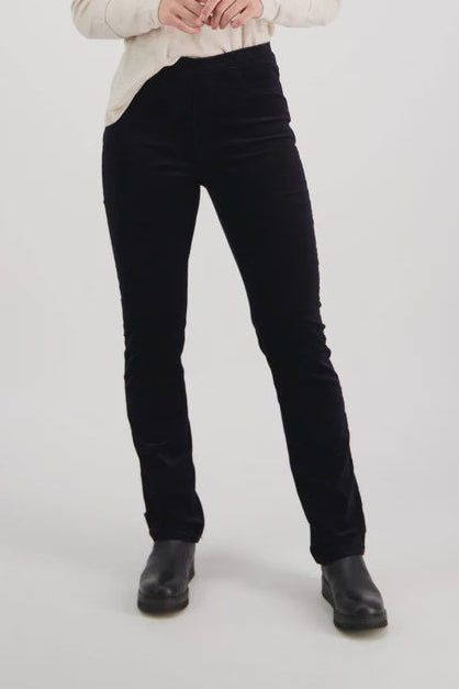 Woman wearing a beige sweater and midnight vassalli cords on a white background