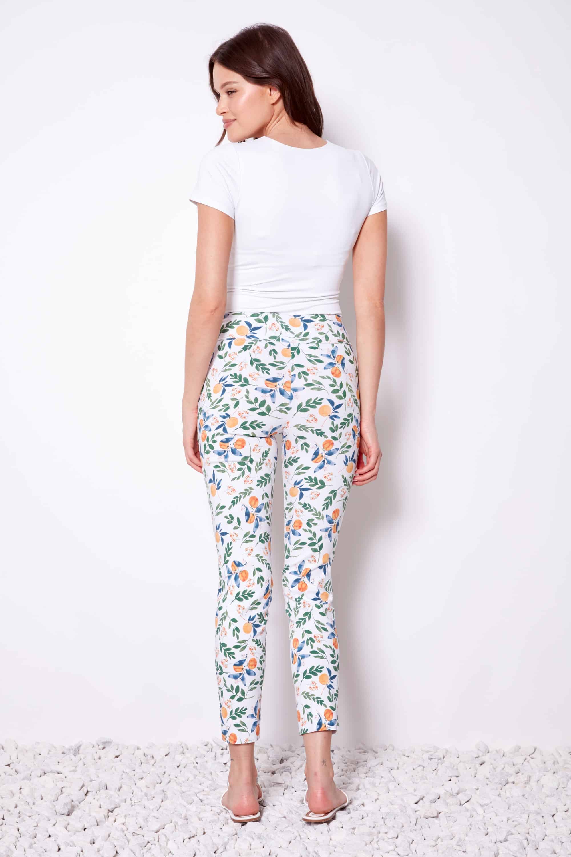 Woman wearing a white t-shirt and floral pants on a white background