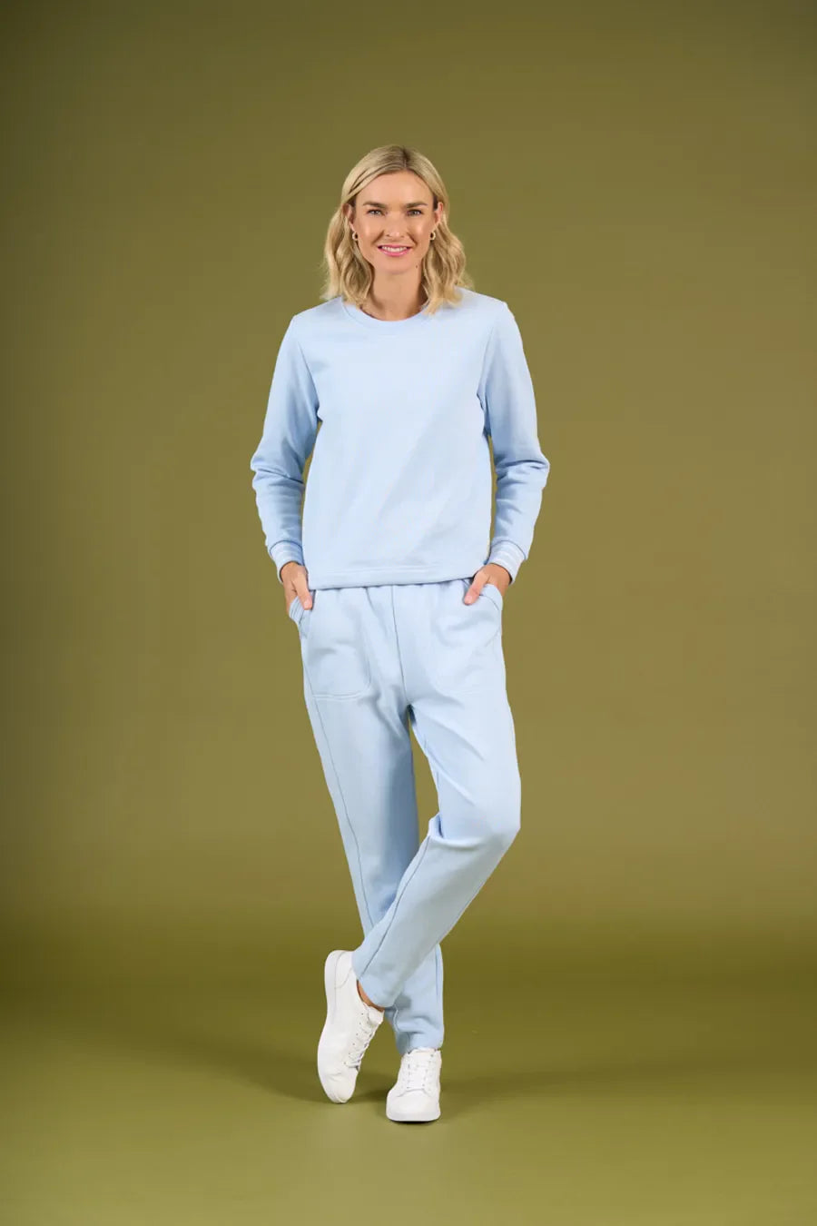 Woman wearing a light blue outfit on an olive green background