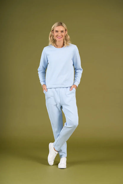 Woman wearing a light blue outfit on an olive green background