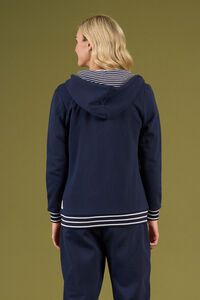 Person wearing a navy blue hoodie with a striped collar on a green background