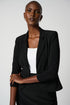 A woman wearing a black classic blazer from Joseph Ribkoff with notched collar and faux front pockets, paired with a white top and a black skirt.