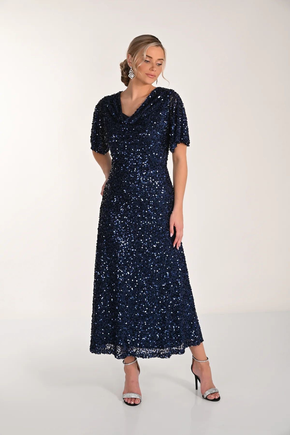 Woman wearing a navy sequin dress on a white background