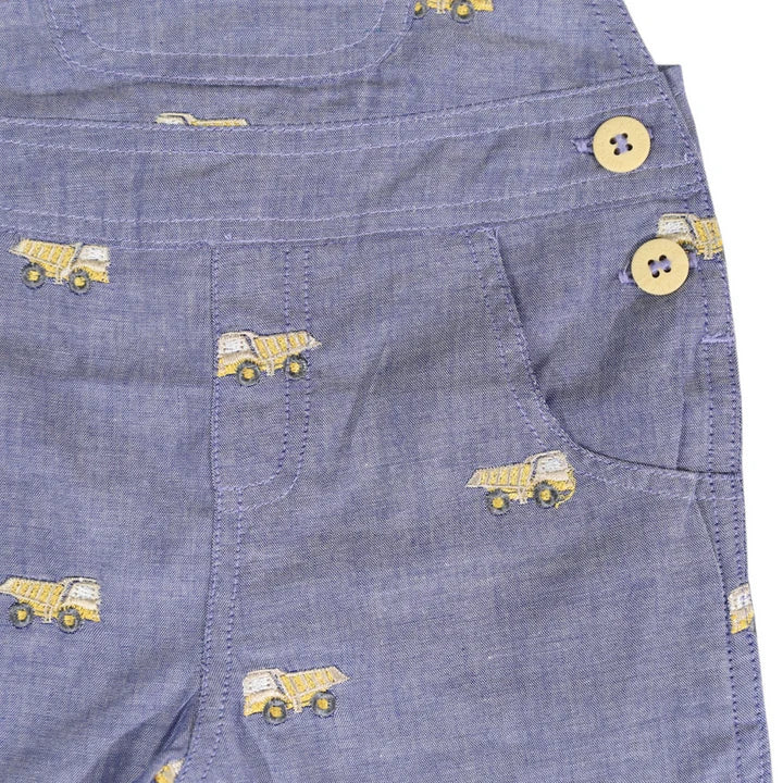 Blue denim shorts with yellow truck patterns and buttons on a white background