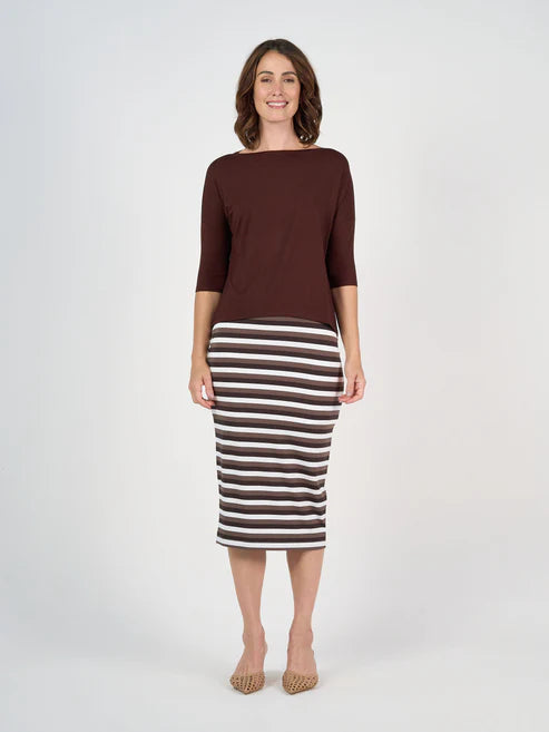 Woman wearing a brown top and striped skirt on a white background