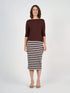 Woman wearing a brown top and striped skirt on a white background