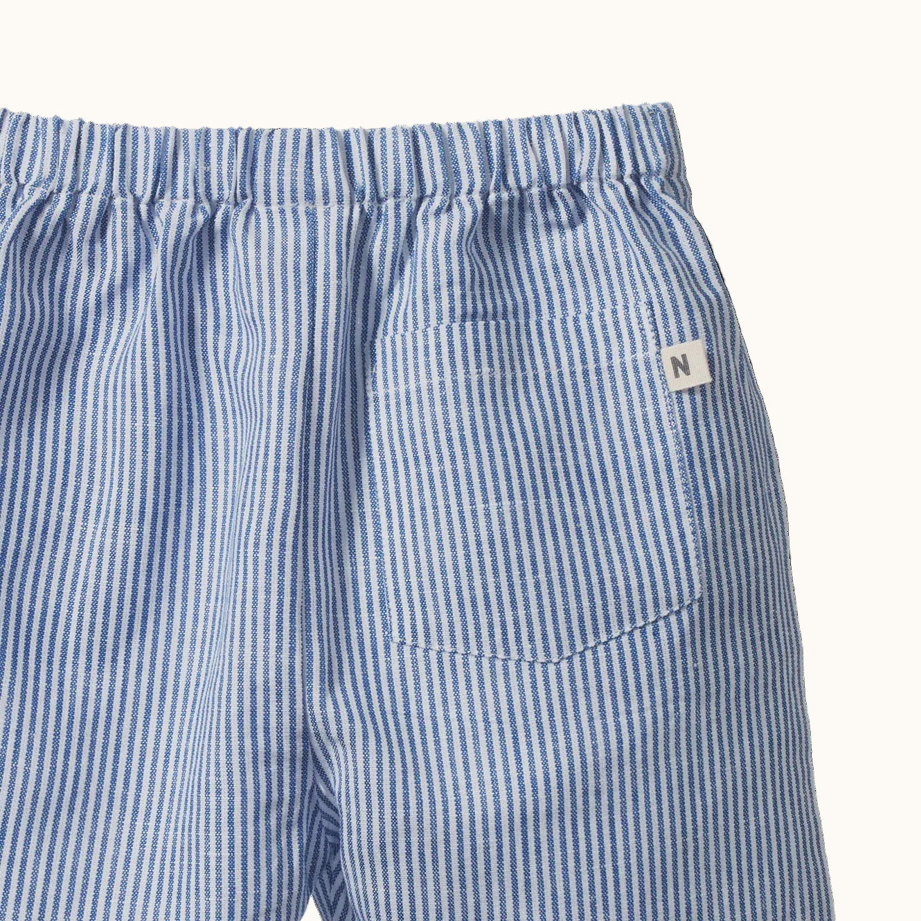 Blue and white striped shorts with a brand logo on a black background
