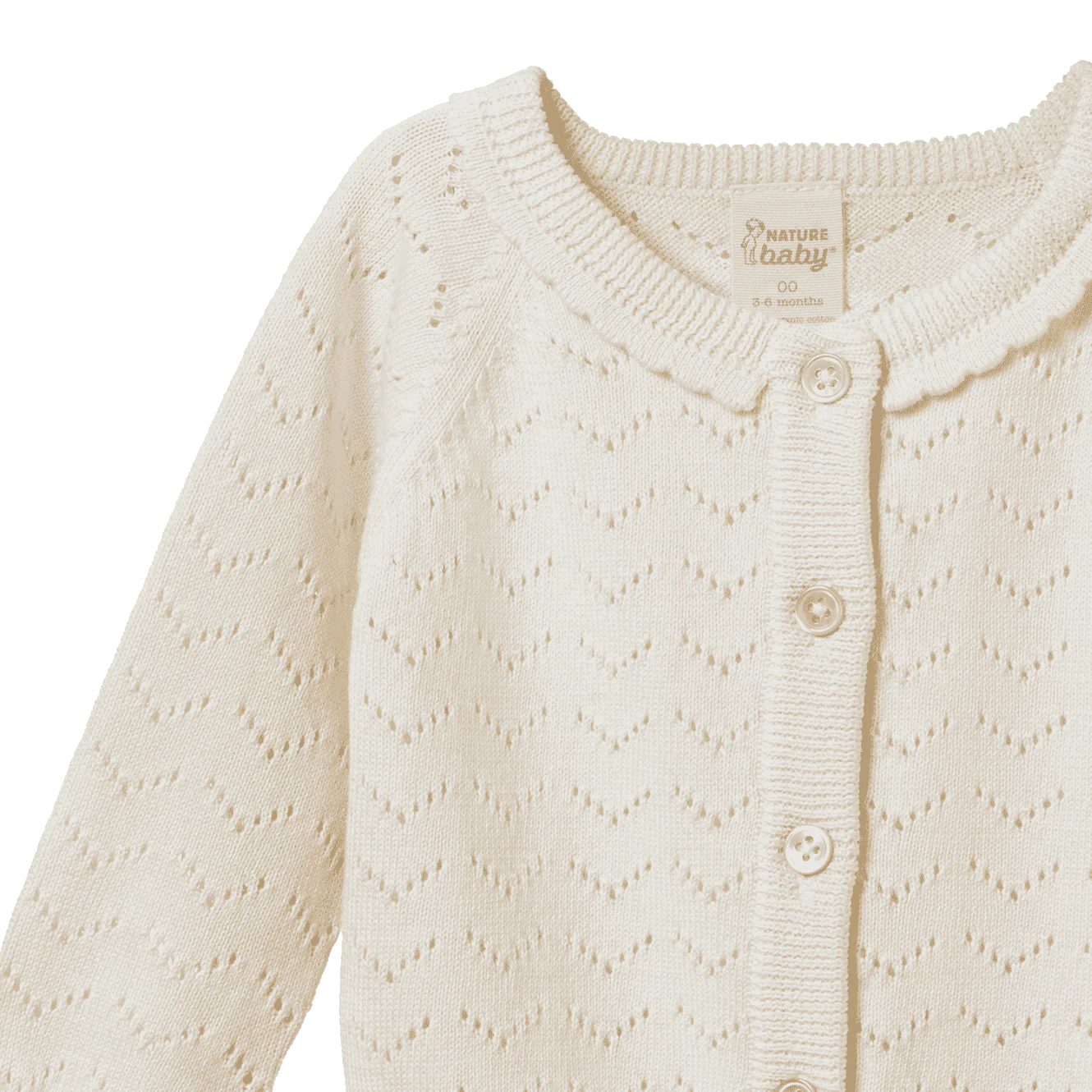 Close-up of a cream-colored baby cardigan with a patterned texture on a white background.