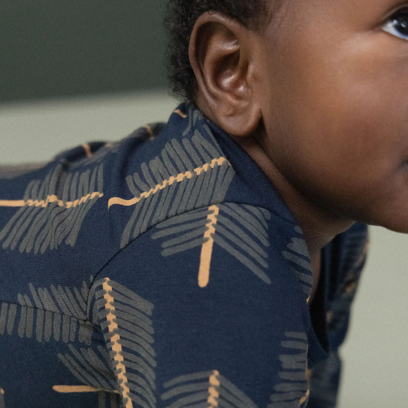 Person wearing a navy blue patterned shirt with gold accents