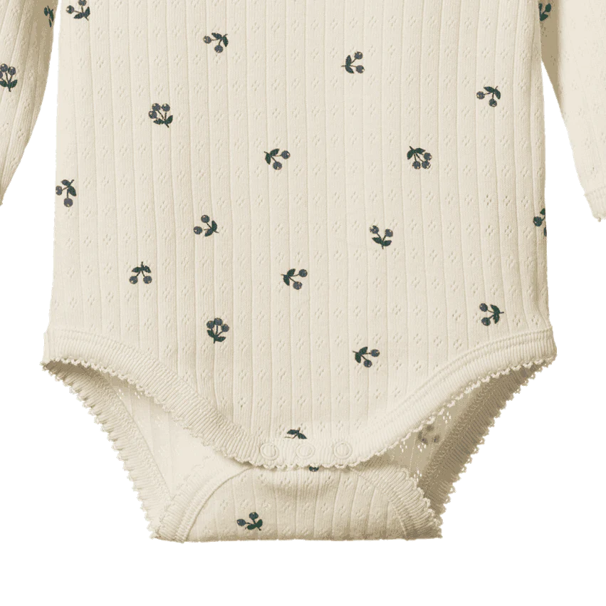 White baby bodysuit with subtle pattern on a white background