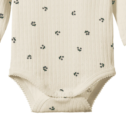 White baby bodysuit with subtle pattern on a white background