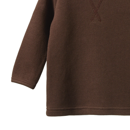 Close-up of a brown textured sweater on a white background