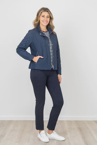 Woman wearing a navy jacket and pants with a white background