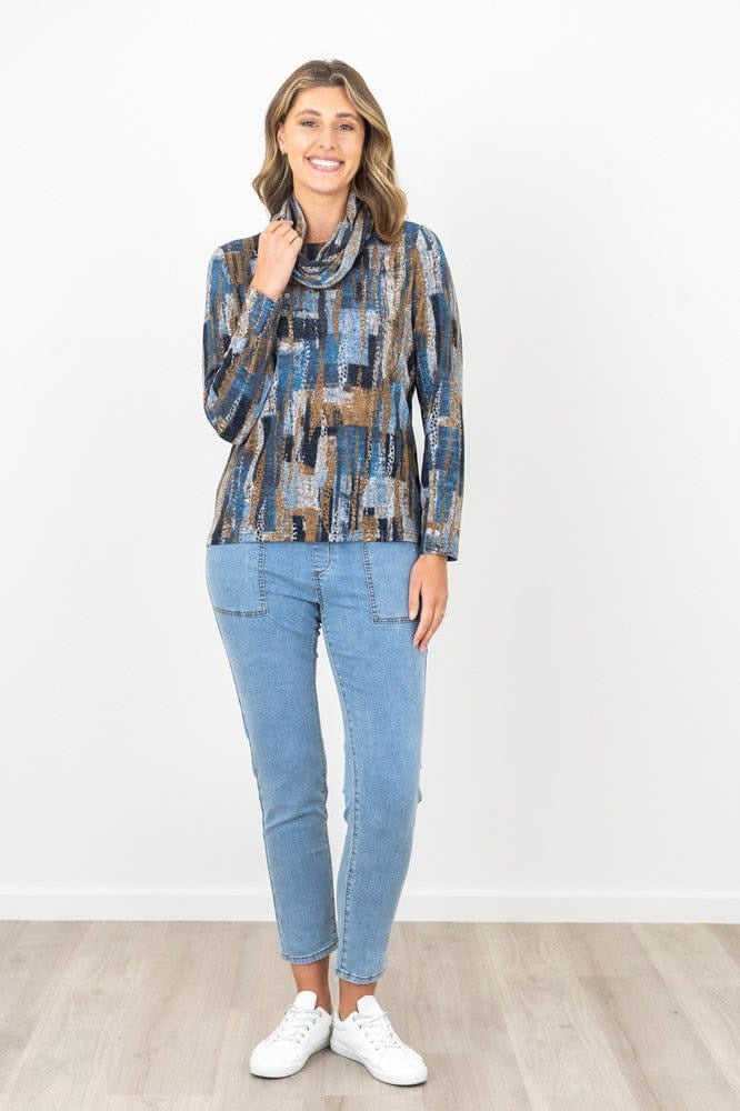 Woman wearing a patterned top and jeans on a white background