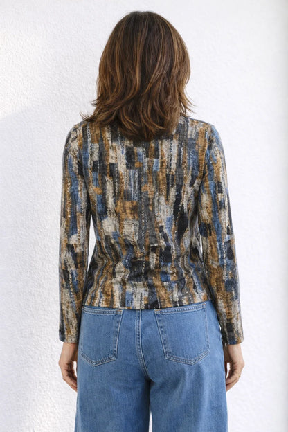 Person wearing a patterned jacket and blue jeans against a white background