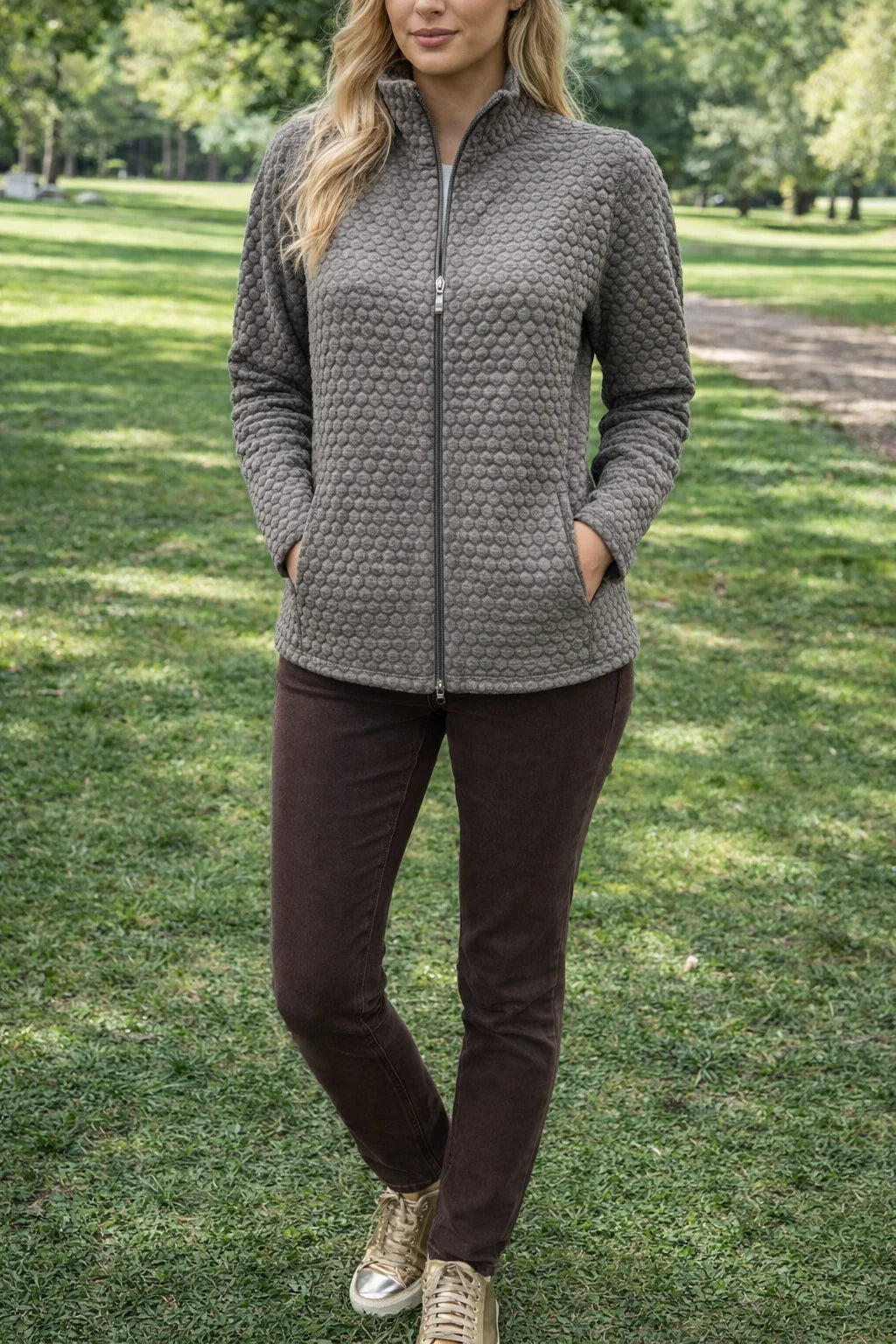 Woman wearing a textured gray jacket in a park setting