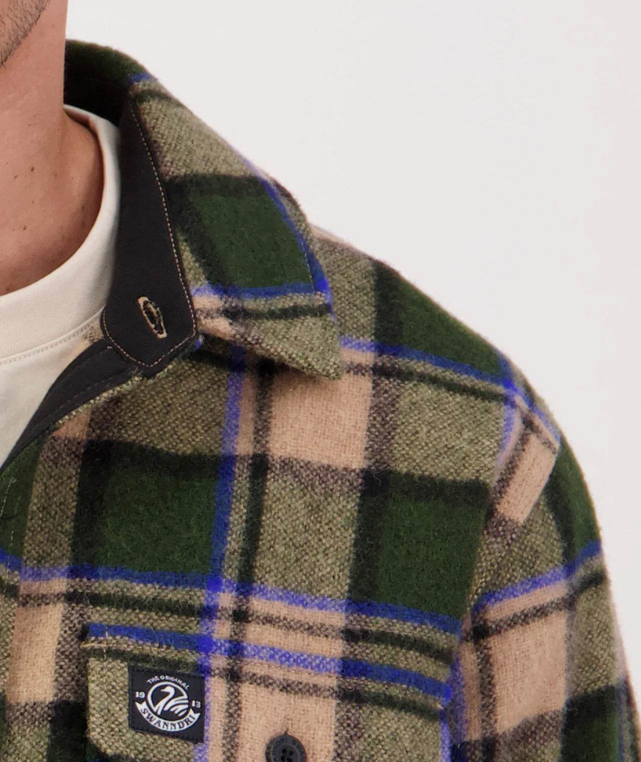 Green and beige plaid coat with a brand logo on a white background