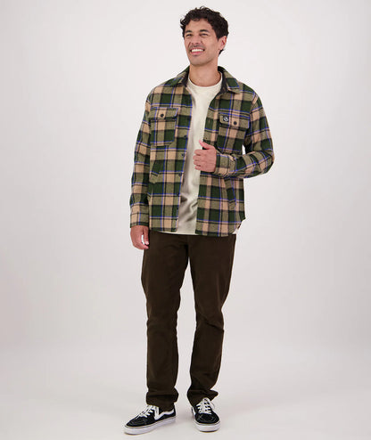 Man wearing a plaid shirt and dark pants on a white background