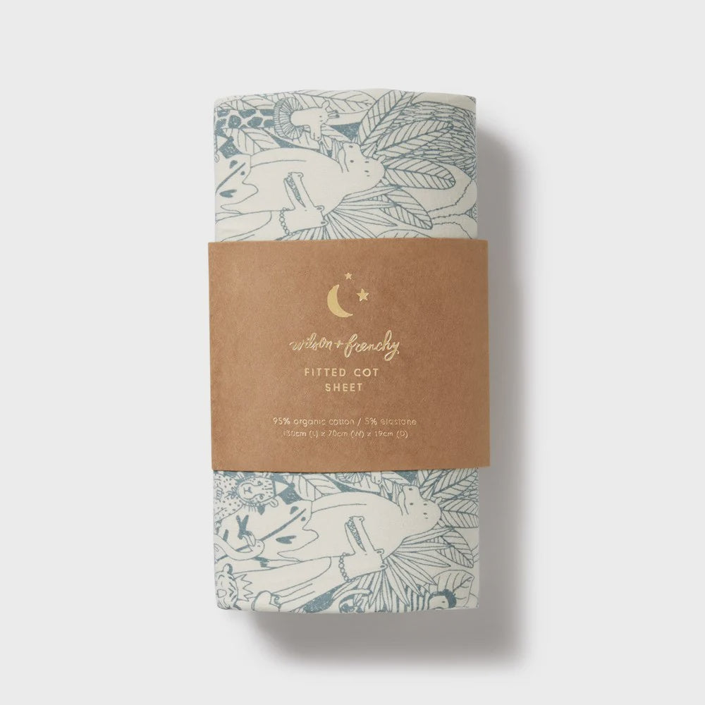 Fitted cot sheet with fox design on a cardboard packaging against a white background