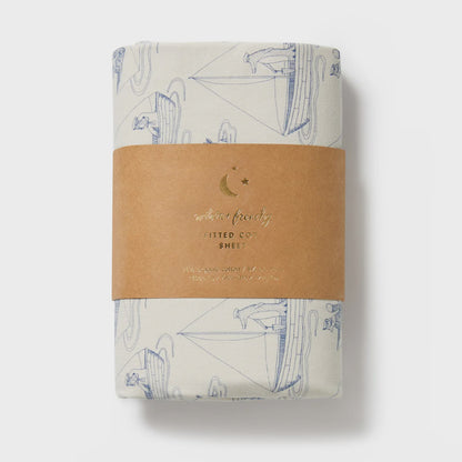 Folded fabric with sailboat pattern and brown label on a white background
