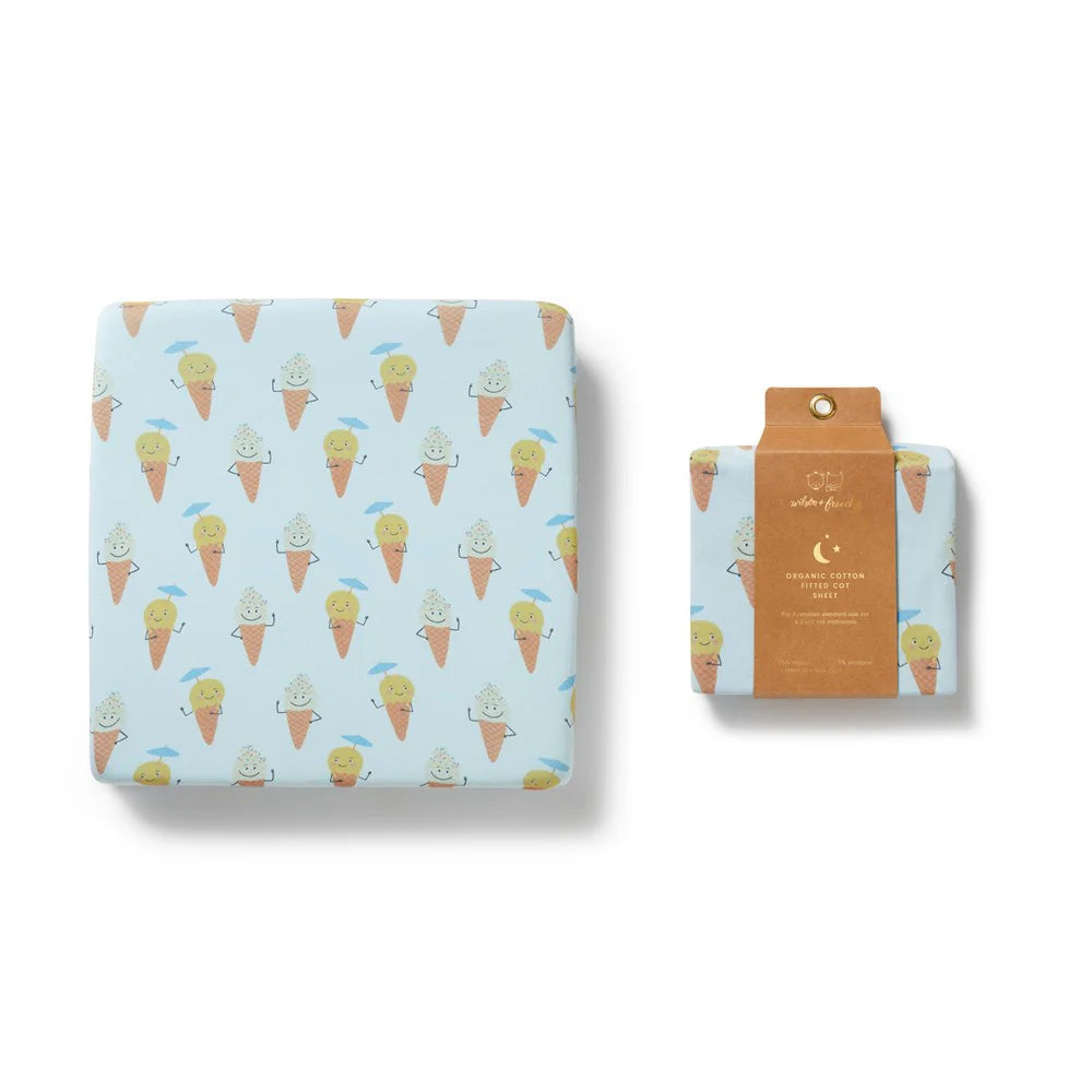 Fitted crib sheet with ice cream cone pattern on a light blue background, displayed with packaging.