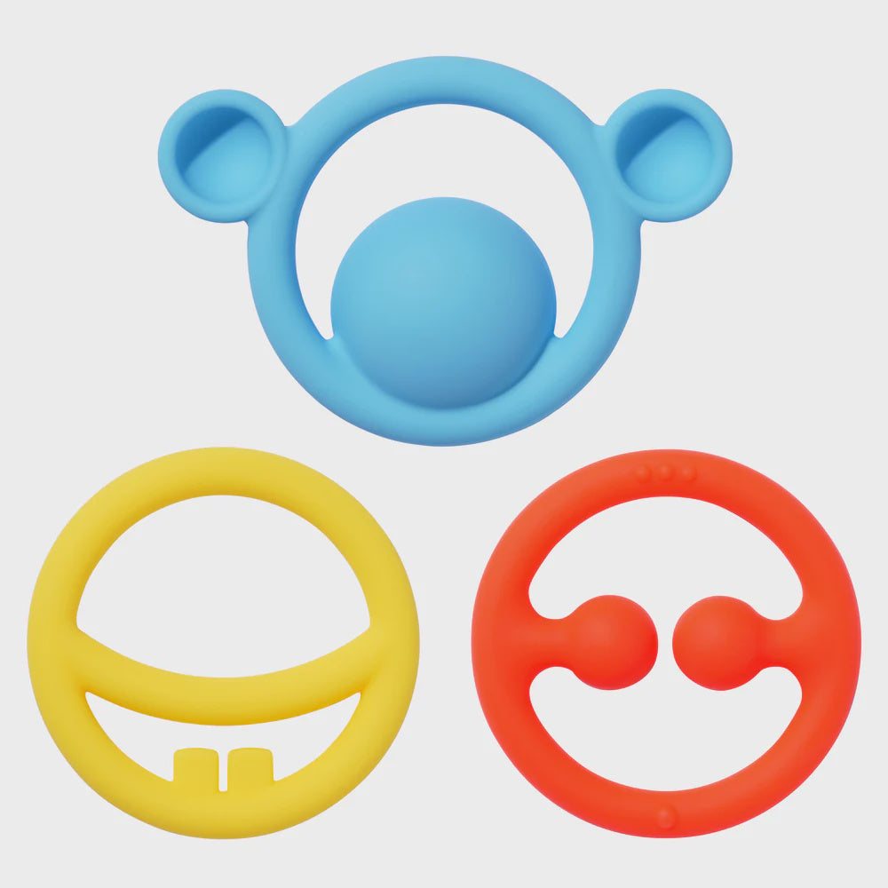 Three colorful silicone teething rings on a light gray background