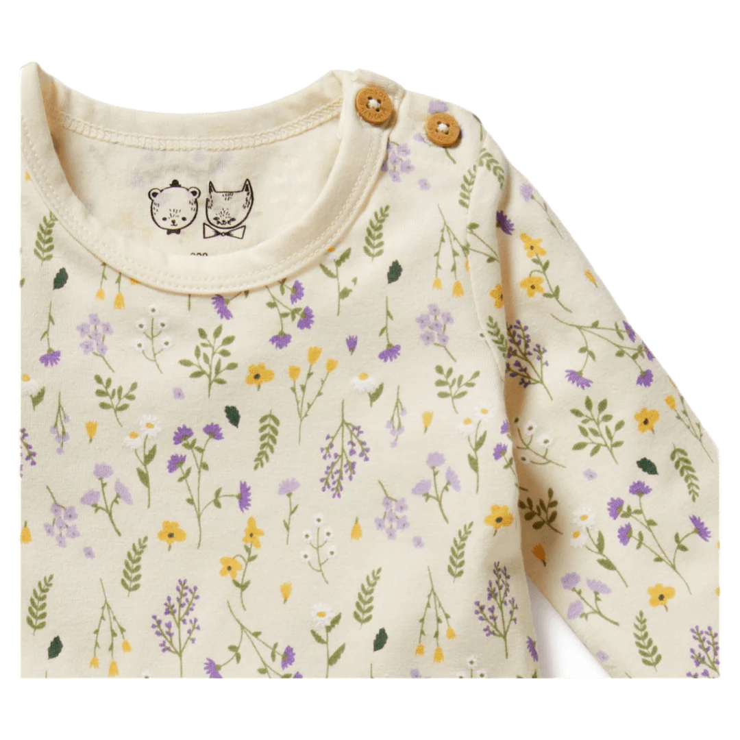 Baby outfit with floral pattern and wooden buttons on a white background