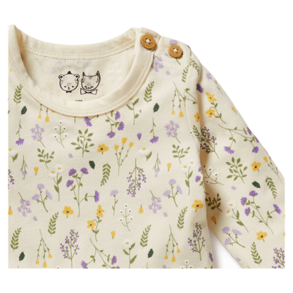 Baby outfit with floral pattern and wooden buttons on a white background
